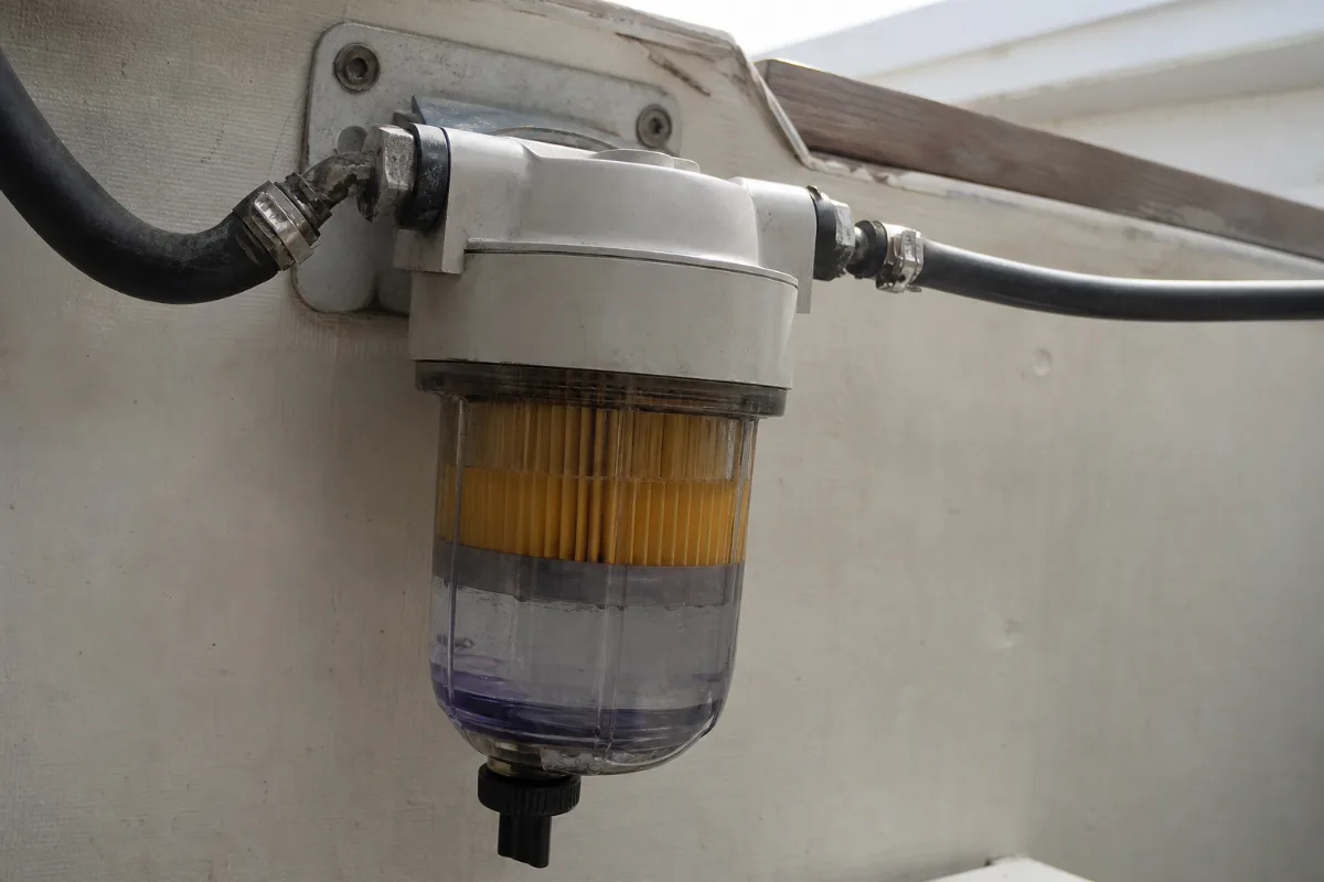 A water-separating fuel filter with a clear bowl showing water collected under the fuel.