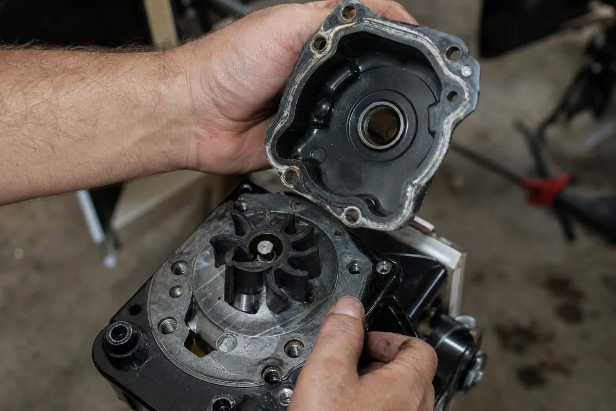An old outboard impeller still on the driveshaft with its vanes curled into a permanent set and one split.